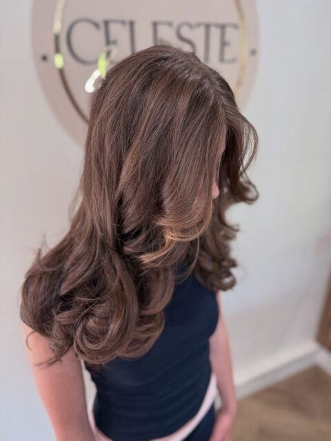 layered haircut with face-framing, finished with curls